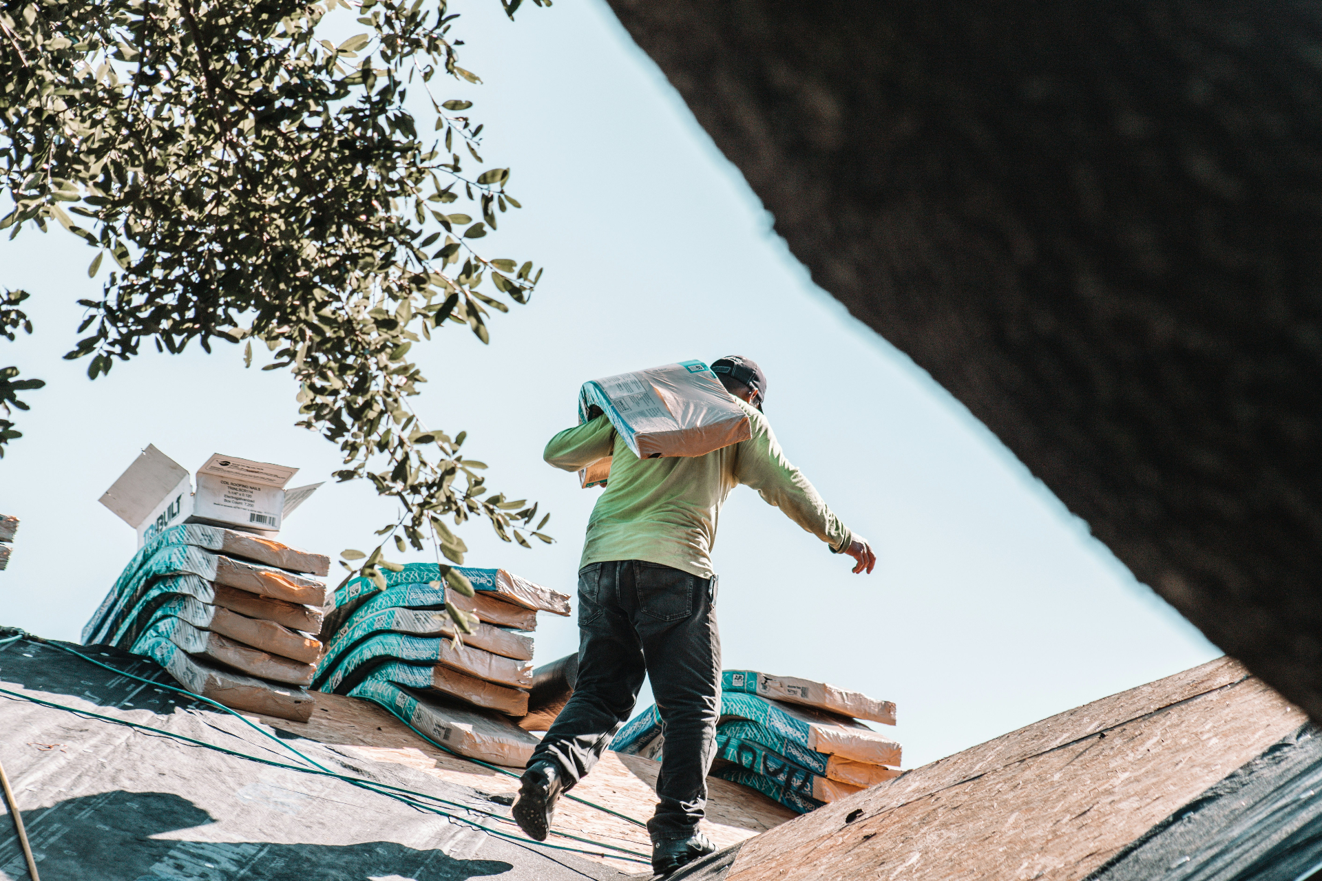 Roofer carrying shingles on a Connecticut jobsite