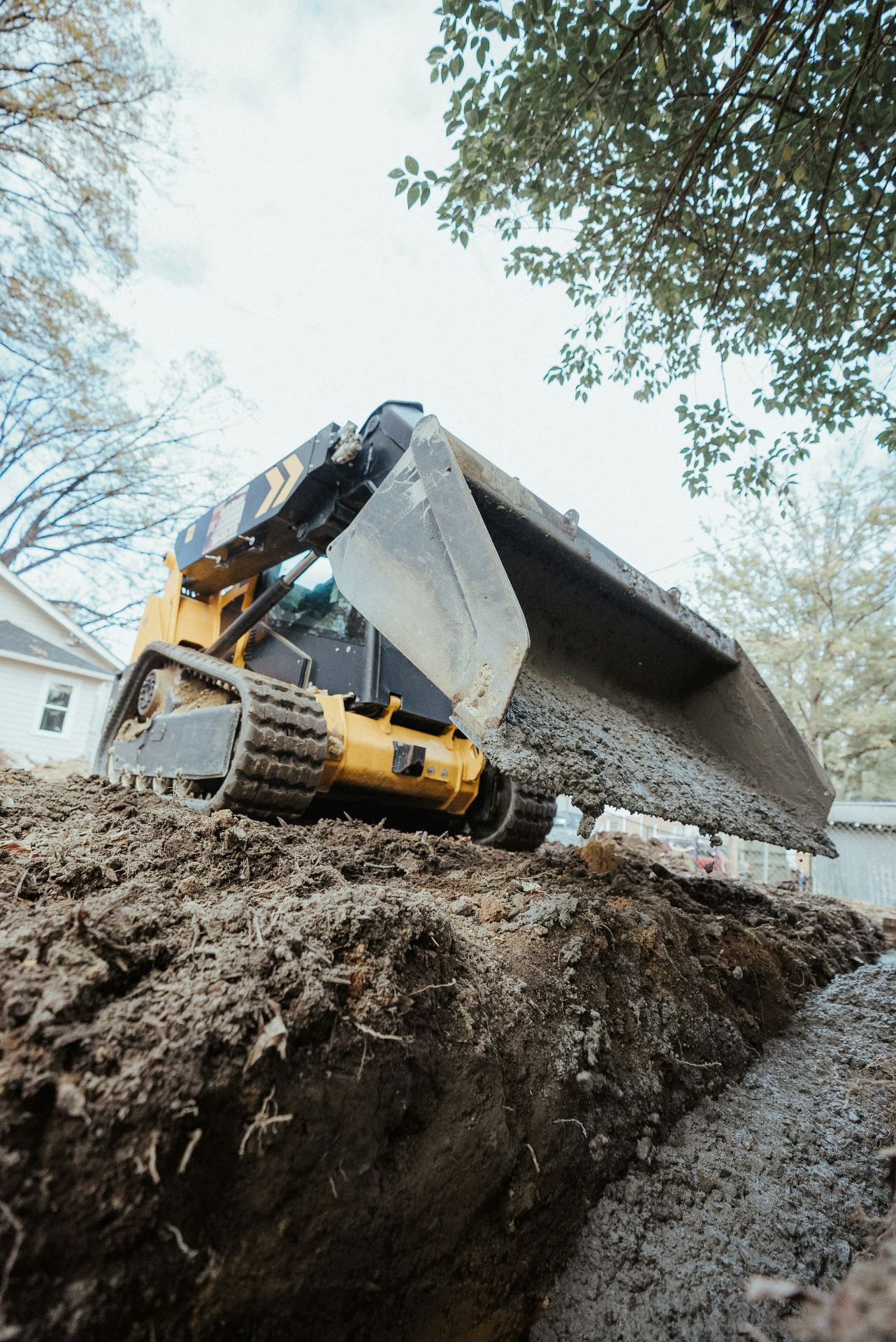 Skid steer excavating dirt on a residential Connecticut jobsite
